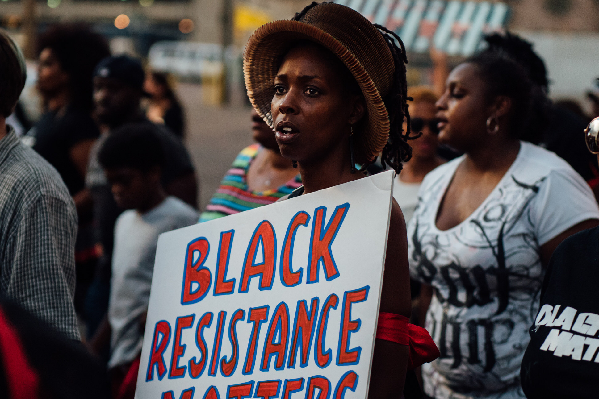 A participant of the BLM 5280 march holds a sign that reads "Black resistance Matters".