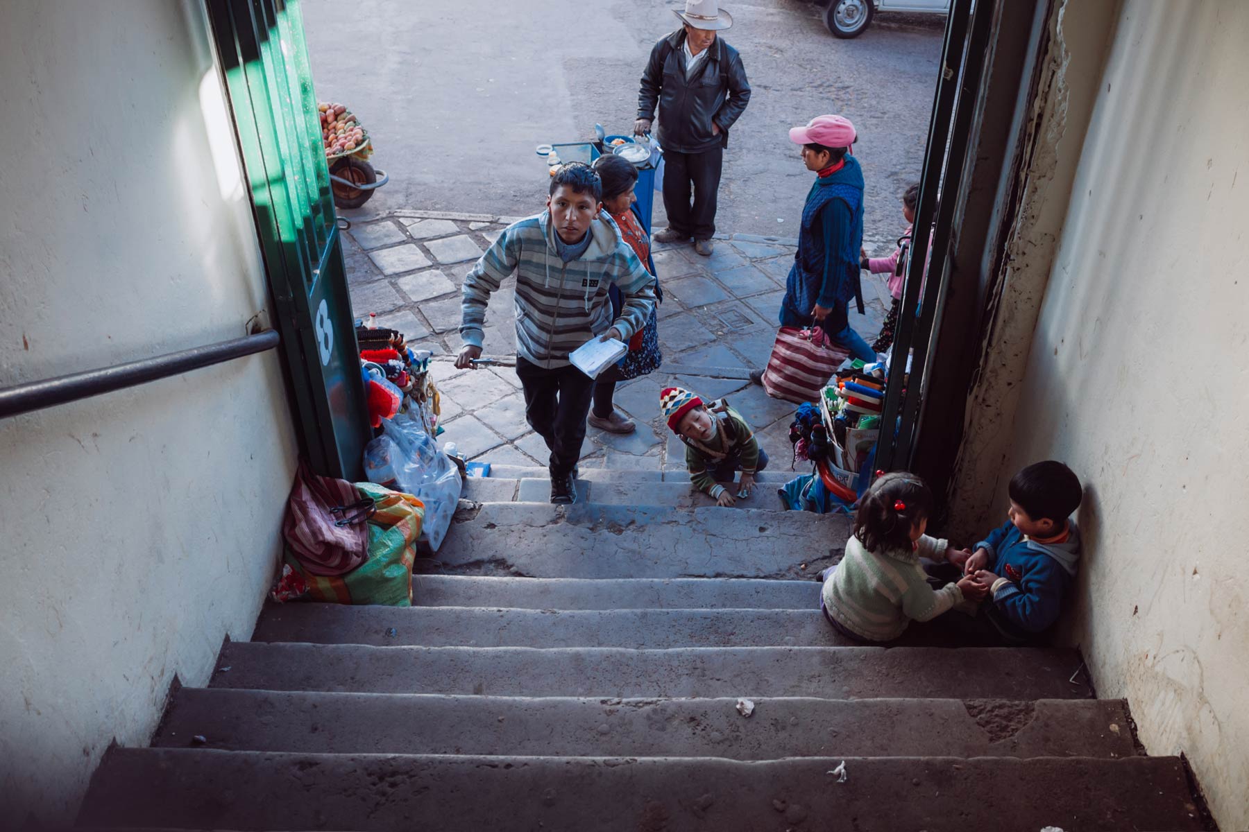 A young boy quickly ascends the steps of a local meat market in Cusco.