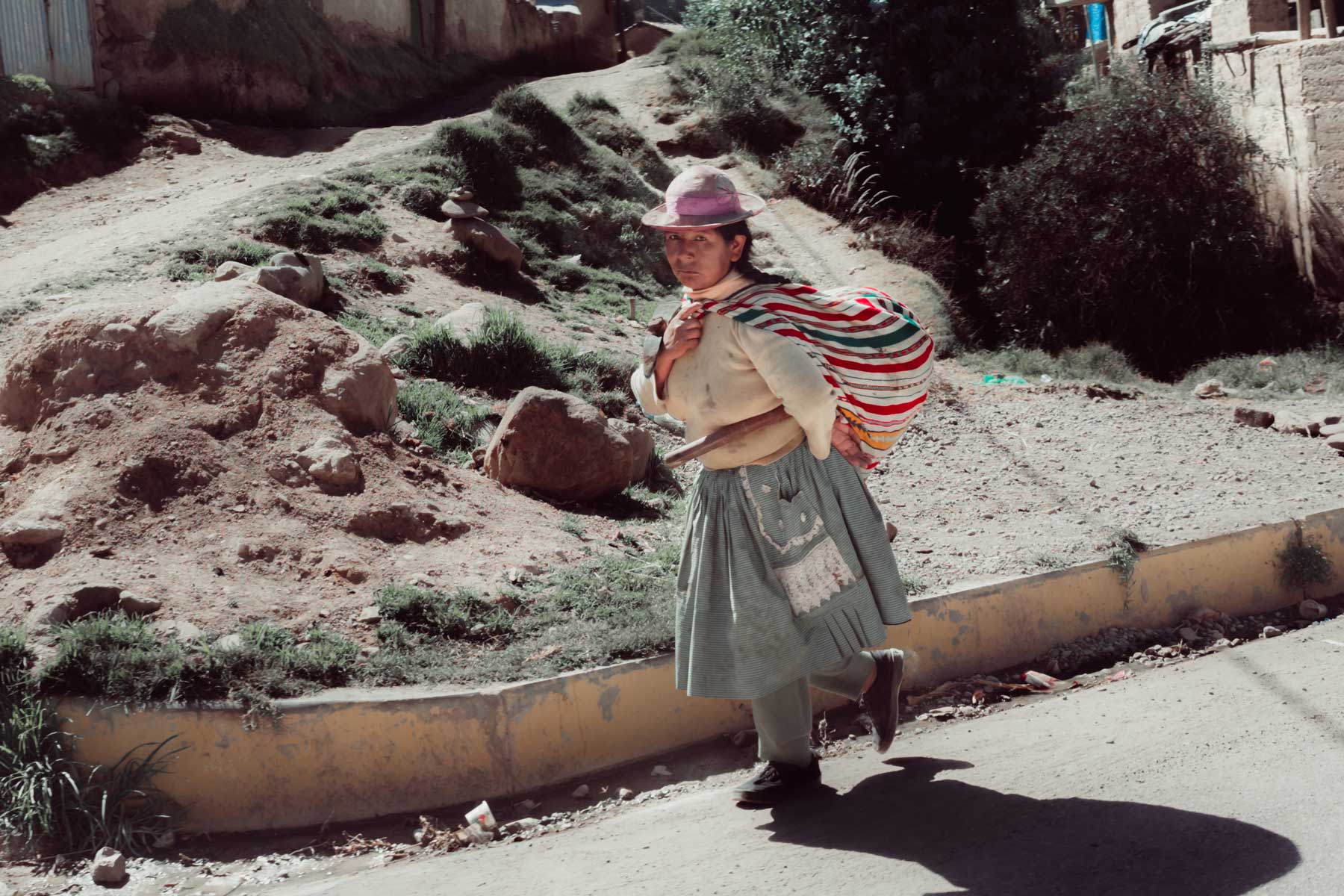 A woman carrying a pickaxe and shovel after a day of work in Hualhuas.