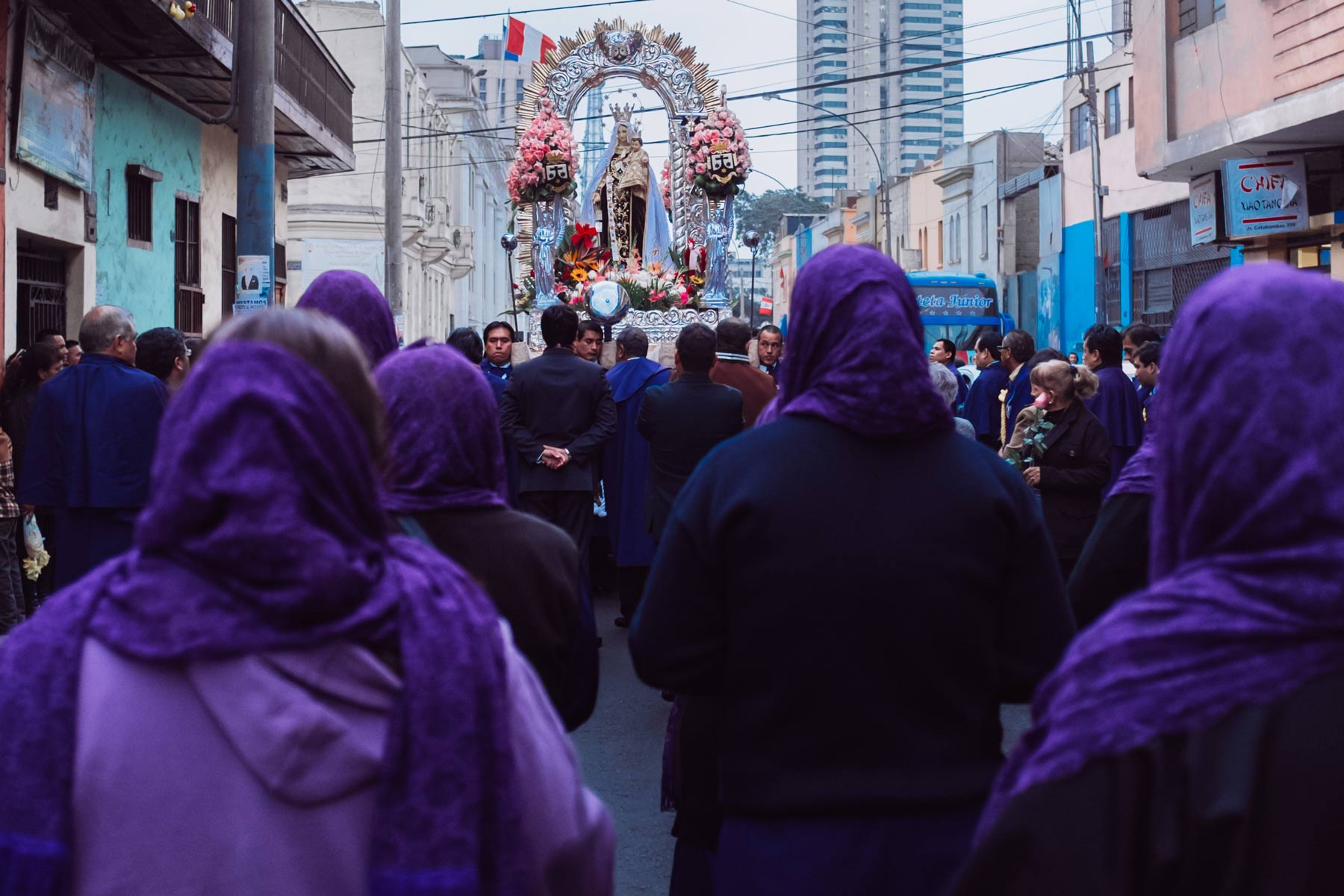 The procession of the Virgin Mary takes place in a small neighborhood in Lima.